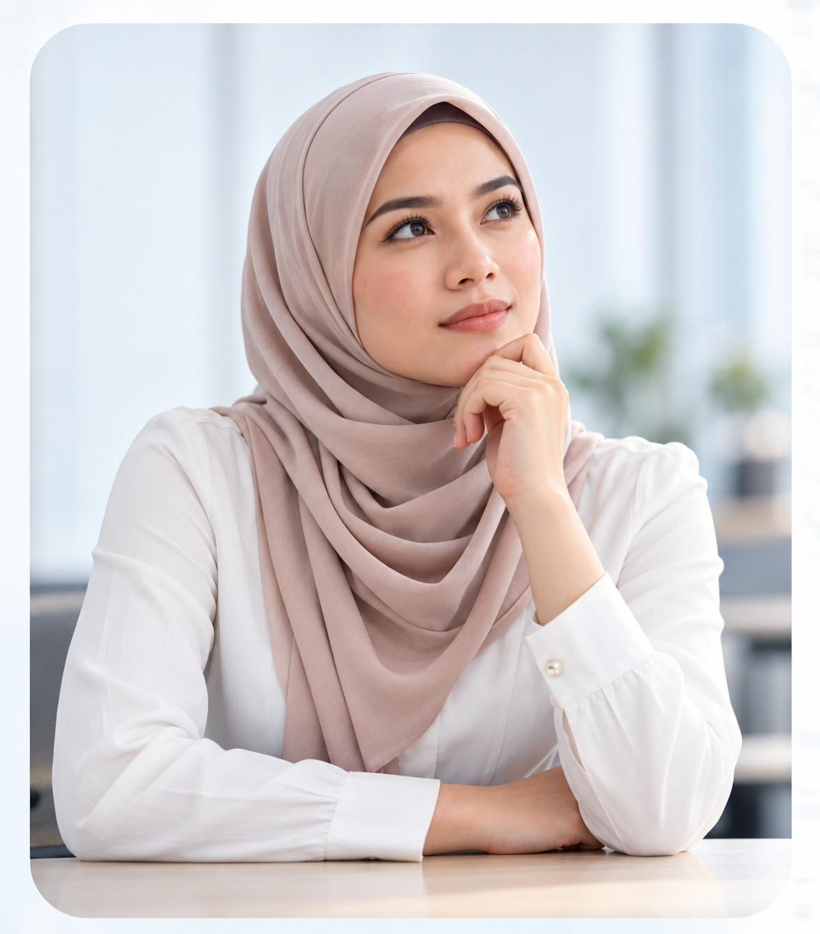 Wanita berhijab merenung di ruang pejabat yang terang